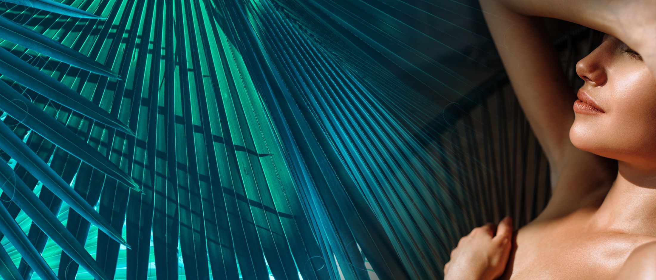 Woman relaxing with palm leaves in background.
