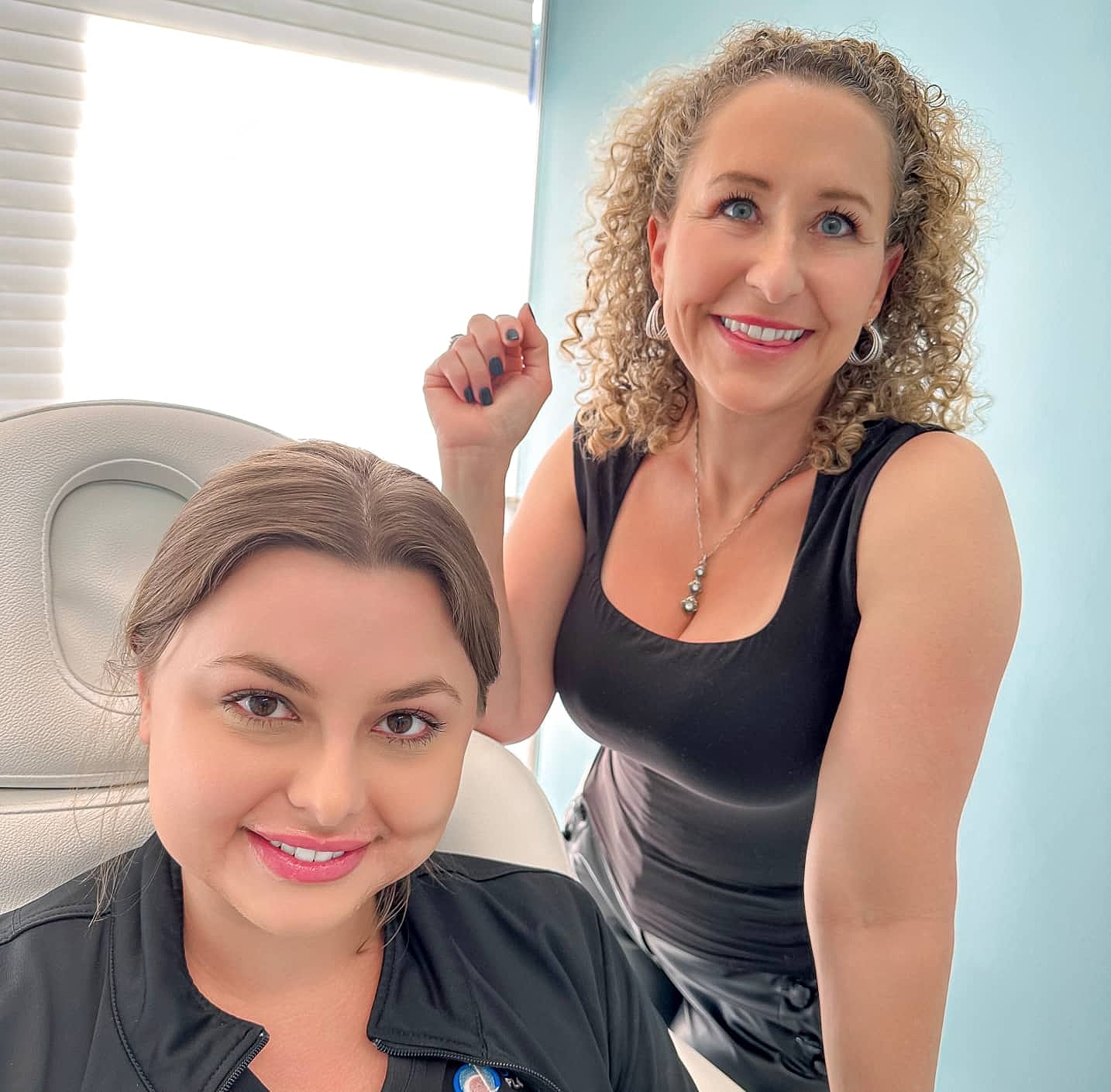 Two women smiling in a bright office.