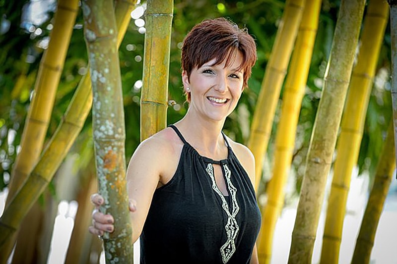 Smiling woman standing by bamboo trees