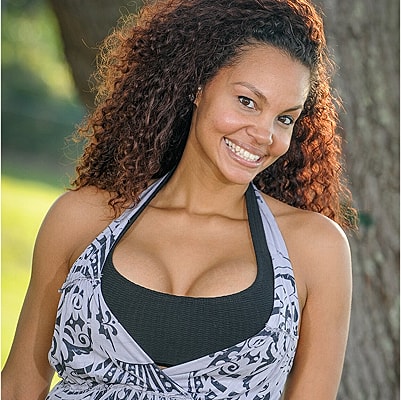 Smiling woman outdoors in stylish attire.