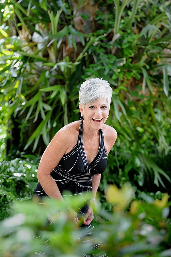 Smiling woman in a garden setting.