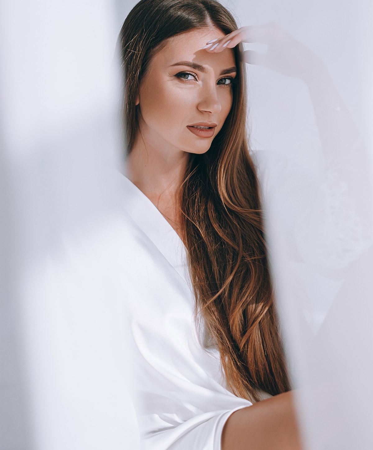Woman with long hair in a white setting.