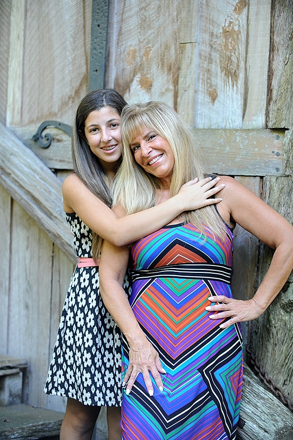 Mother and daughter smiling together outdoors.