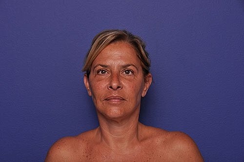 Portrait of woman against purple background.