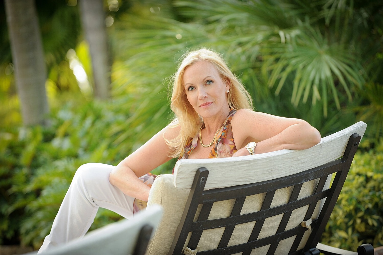 Woman relaxing on a chair surrounded by greenery.