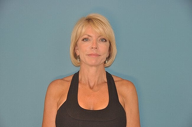 Woman in fitness attire against blue background.