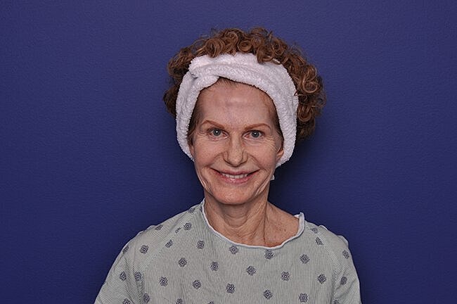 Smiling woman with curly hair and headband.