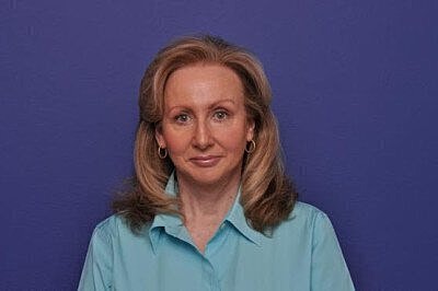 Woman with long hair against a purple background.