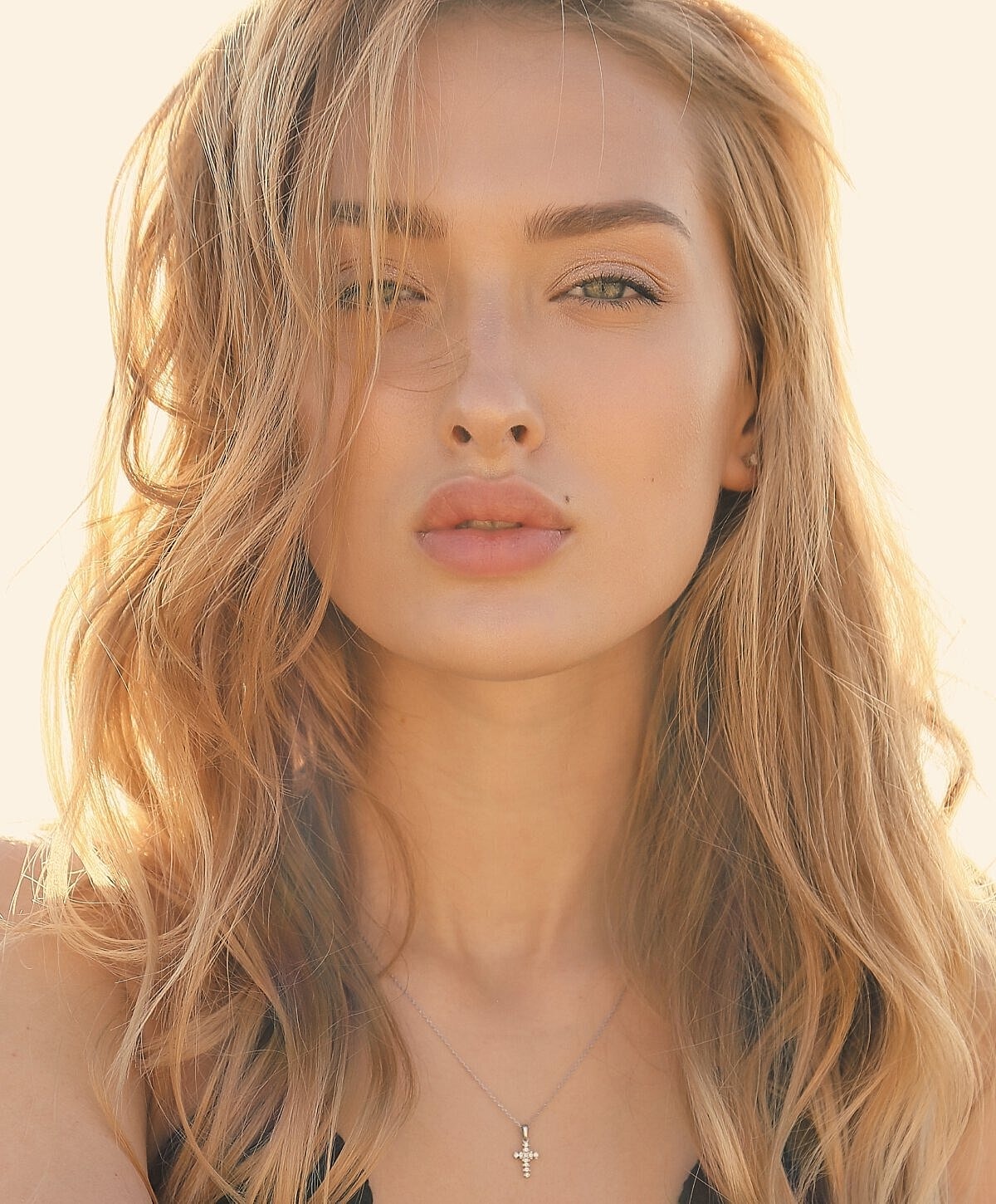 Woman with long wavy hair and subtle makeup.