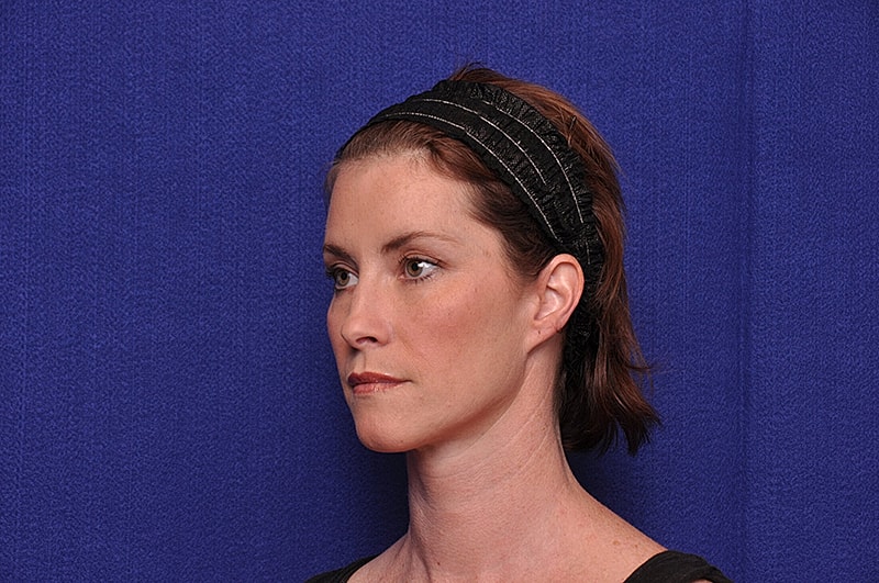 Woman with headband against blue background.
