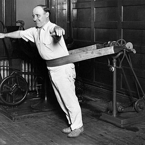 Man using vintage exercise equipment in gym.