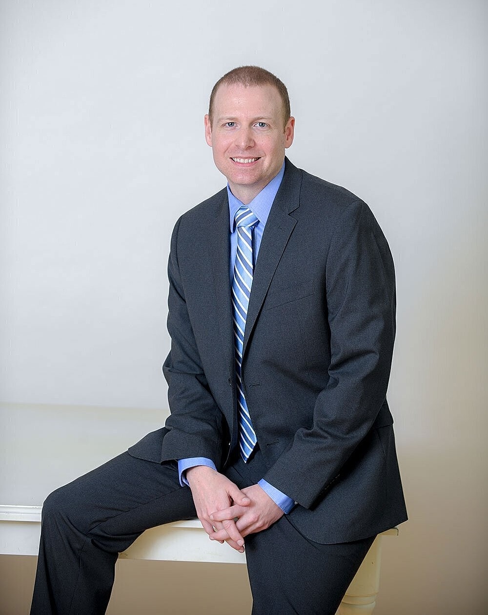 Man in suit sitting confidently for portrait.