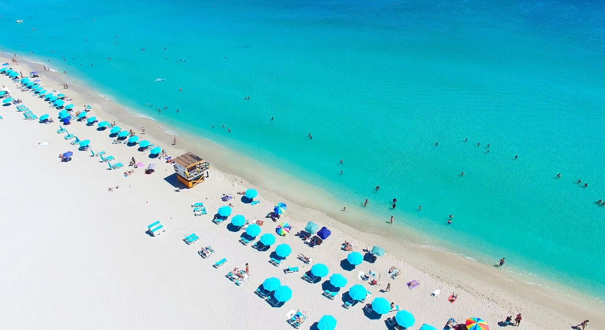 Tropical beach with umbrellas and clear water.
