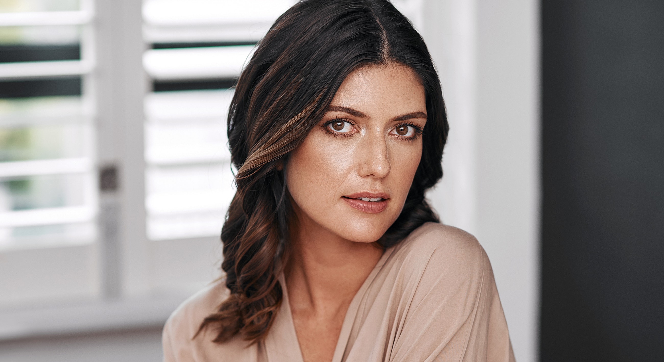 Smiling woman in a cozy café setting.